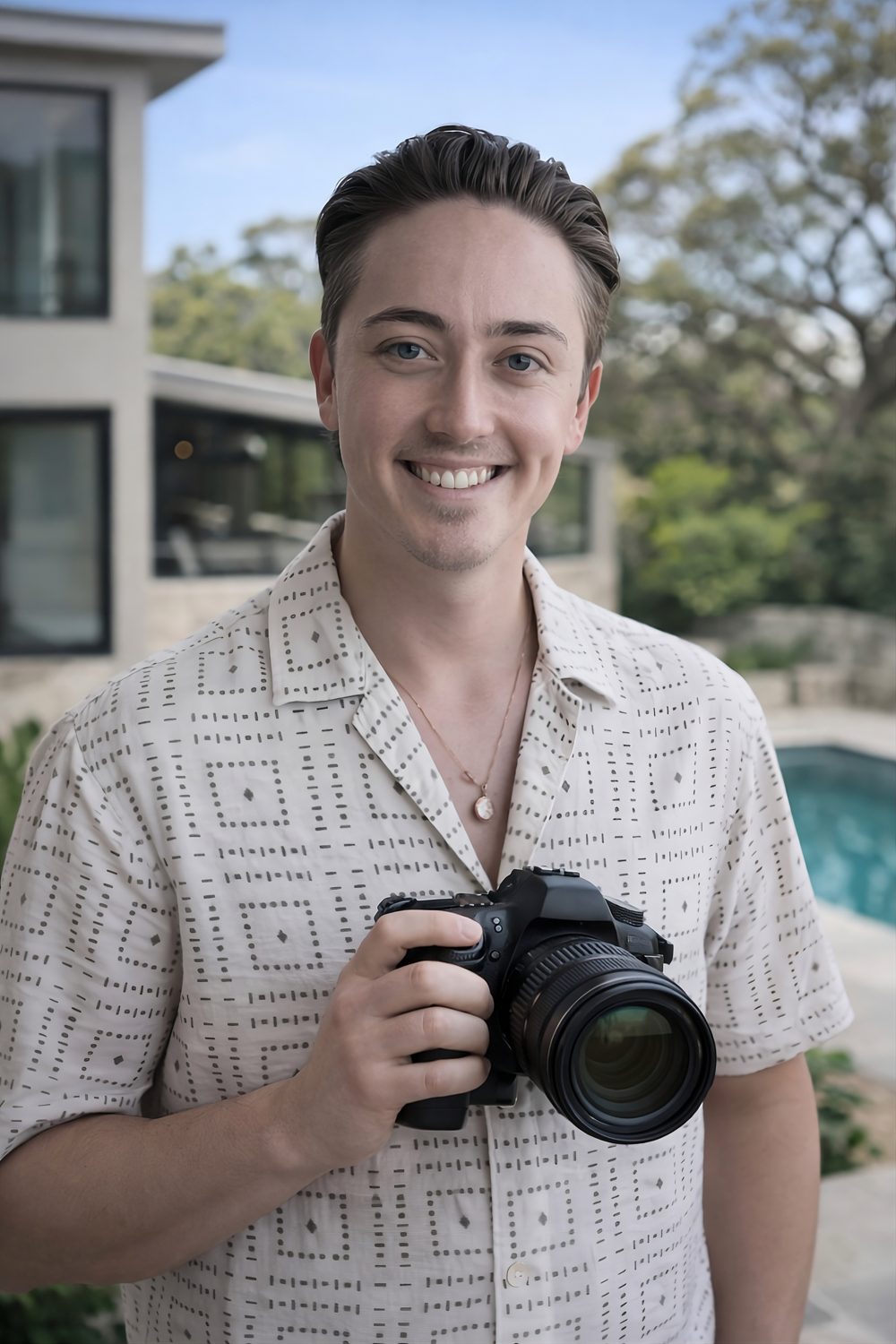 Jack, property photographer, holding a camera beside a pool at a short-stay property